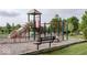 Community playground with slide, climbing structures, and bench at 653 Springdale Ln, Greenfield, IN 46140