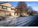 Two-story tan townhome with attached garage and snowy front yard at 7042 Tyler Ln, Indianapolis, IN 46217