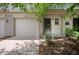 Charming townhome featuring an attached garage, a welcoming front door, and landscaped grounds at 7042 Tyler Ln, Indianapolis, IN 46217