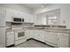 White kitchen with granite countertops and stainless steel appliances at 7042 Tyler Ln, Indianapolis, IN 46217
