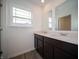 Bathroom with double sink vanity featuring modern fixtures, ample lighting, and stylish flooring at 7824 Magnolia St, New Palestine, IN 46163