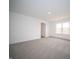 An inviting bedroom showcases neutral carpet and a window, and an open door into the hallway and entry to another room at 7824 Magnolia St, New Palestine, IN 46163