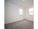 Empty bedroom with neutral carpet and natural light from two windows at 7824 Magnolia St, New Palestine, IN 46163