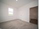 Empty bedroom with neutral carpet and one window looking out on a green field at 7824 Magnolia St, New Palestine, IN 46163