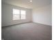 Bright bedroom featuring neutral carpet, a double window bringing in natural light, and fresh, white painted walls at 7824 Magnolia St, New Palestine, IN 46163