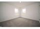 Bright bedroom featuring two windows and neutral carpeting for a serene living space at 7824 Magnolia St, New Palestine, IN 46163