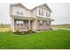 Beautiful two-story home with brick and siding, complemented by a green lawn and landscaping at 7824 Magnolia St, New Palestine, IN 46163