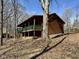 Cabin featuring a wraparound porch with green trim nestled among mature trees at 7887 Elk Dr, Nineveh, IN 46164