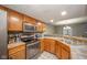 Kitchen with stainless steel appliances and oak cabinets, open to dining area at 8022 Talliho Dr, Indianapolis, IN 46256