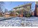 Green sided two-story home with brick details and a snowy yard at 814 N Audubon Rd, Indianapolis, IN 46219