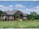 Brick ranch home with gray roof, manicured lawn, and mature trees at 8152 Cottonwood Dr, Martinsville, IN 46151