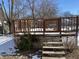 Wooden deck with stairs and railings, partially covered in snow at 8531 Friendship Ln, Indianapolis, IN 46217