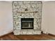 Close-up of a stone fireplace with a wooden mantle, creating a cozy focal point in the living space at 8660 S Peoga Rd, Trafalgar, IN 46181