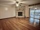 Expansive living room featuring a stone fireplace, hardwood floors, and sliding door leading to the back deck at 8660 S Peoga Rd, Trafalgar, IN 46181