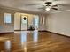 Bright living room with hardwood floors, ceiling fan, and a front door adorned with a wreath at 8660 S Peoga Rd, Trafalgar, IN 46181