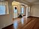 Cozy living room with hardwood floors, decorative curtains, and a door with a wreath at 8660 S Peoga Rd, Trafalgar, IN 46181