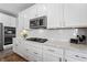 Modern kitchen with white cabinets, granite countertops, and gas cooktop at 9847 Gallop Ln, Fishers, IN 46040