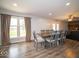 Bright dining area with large table and chairs, hardwood floors, and view to backyard at 9876 Woodbriar Ln, Carmel, IN 46280