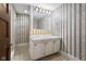 Clean bathroom with white vanity, mirror, and patterned wallpaper at 1023 Franklin St, Columbus, IN 47201