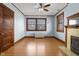 Light blue bedroom with hardwood floors, ceiling fan, and vintage fireplace at 1023 Franklin St, Columbus, IN 47201