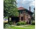 Angle view showcasing the home's brick exterior, covered porch, and surrounding greenery at 1023 Franklin St, Columbus, IN 47201