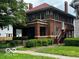 Charming two-story brick home with a covered front porch and well-maintained landscaping at 1023 Franklin St, Columbus, IN 47201