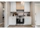 Modern kitchen with white cabinets, stone backsplash, and stainless steel appliances at 132 W 41St St, Indianapolis, IN 46208