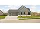 Gray farmhouse with a two car garage and large driveway. Landscaped yard and stone accents at 14028 Grannan Ln, Carmel, IN 46074