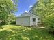 Side view of exterior with green grass, lush trees, and natural light at 1610 Hoefgen St, Indianapolis, IN 46203