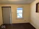 Bright bedroom with a window and grey door at 1610 Hoefgen St, Indianapolis, IN 46203