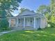 Charming single-story home featuring a welcoming front porch, freshly painted siding, and well-maintained landscaping at 1610 Hoefgen St, Indianapolis, IN 46203