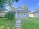 Inviting single-story house with a cozy front porch, concrete steps, and freshly painted siding at 1610 Hoefgen St, Indianapolis, IN 46203