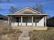 Modest bungalow with covered porch and two entry doors under a simple gable roof, offering potential for dual occupancy at 1610 Hoefgen St, Indianapolis, IN 46203