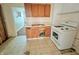 Outdated kitchen with wood cabinets, worn flooring, and a white gas range in need of updating and repair at 1610 Hoefgen St, Indianapolis, IN 46203
