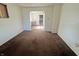Empty living room featuring archway with visible kitchen and brown carpeted floors at 1610 Hoefgen St, Indianapolis, IN 46203