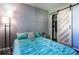 Bedroom with teal bedding, barn door, and closet at 1654 Iowa St, Indianapolis, IN 46203