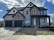Two-story home with gray brick, black trim, gabled roof, covered entry, and two-car garage at 19962 Stone Side Ct, Westfield, IN 46074