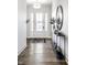 Elegant foyer with a white front door, wood floors, stylish console table, and a decorative mirror at 20188 Hampton Park Dr, Westfield, IN 46074