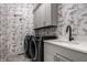Stylish laundry room with floral wallpaper, modern washer/dryer, and ample storage space at 20188 Hampton Park Dr, Westfield, IN 46074