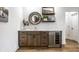 Elegant wet bar includes custom cabinets, wine fridge, floating shelves, round mirror and wood flooring at 20188 Hampton Park Dr, Westfield, IN 46074