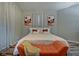 Bright bedroom with king bed, orange bench, and artwork above the bed at 2450 Carrollton Ave, Indianapolis, IN 46205