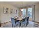 Dining room features a wood table, gray chairs, and large window with curtains at 2450 Carrollton Ave, Indianapolis, IN 46205