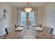 Bright dining area with wood table, gray chairs, and large window with curtains at 2450 Carrollton Ave, Indianapolis, IN 46205