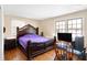 Spacious bedroom with a large bed, hardwood floors, and a home office at 2934 S Irwin St, Indianapolis, IN 46203