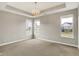 Bright bedroom with neutral walls, carpeted floor, tray ceiling, and a lovely chandelier fixture at 3844 Albert Ln, Bargersville, IN 46106