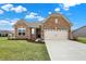 Charming brick home featuring an attached two-car garage and well-manicured front lawn, set against a sunny sky at 3844 Albert Ln, Bargersville, IN 46106
