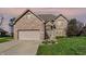 Charming two-story brick home featuring an attached two-car garage and a well-manicured front yard at 386 White Oak Ln, Greenwood, IN 46142