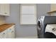 Laundry room with modern appliances, a window, and a butcher block countertop on white cabinets at 386 White Oak Ln, Greenwood, IN 46142