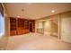 Spacious basement area featuring custom built-in shelving, bar area, and neutral carpeting at 4232 Bunting Ln, Columbus, IN 47203