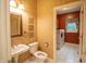 Bathroom featuring a classic pedestal sink, toilet, and a view of the adjacent laundry room at 4232 Bunting Ln, Columbus, IN 47203